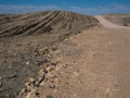 Texture of sandy road trip through dried dusty rock mountain landscape ground of Namib desert background with splitting stone