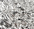 Texture of shiny crumpled piece of gray foil, packaging material for food and objects