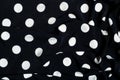 texture of silk fabric. background. white polka dots on a black