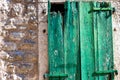 Texture of stone wall with part of wooden green shutters, background