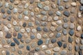 Texture of a stone wall or road from small round and oval stones with sand. natural old background Royalty Free Stock Photo