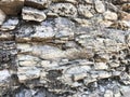 The texture of the stone wall of sharp cracked convex rough natural gray puff of old ancient stone bricks in the rock. Royalty Free Stock Photo