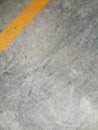 Texture surface of grey concrete road with scratches, indents and chipped with yellow lane divider line with copy space. Royalty Free Stock Photo