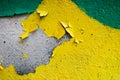 Texture of a two-color yellow and green old shabby concrete wall with bulbous peeling varicoloured paint, pits and patterns