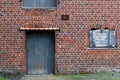 Texture view, a red and weathered brick wall with a blue old door  and a small window with a closed blue painted wooden board. Use Royalty Free Stock Photo