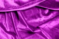 Texture of a wavy surface of a violet velvet fabric