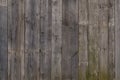 The texture of weathered wooden wall. Aged wooden plank fence of vertical flat board