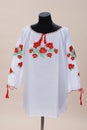 Texture of white fabric, hand-embroidered with red poppies, close-up. Vyshyvanka, traditional folk ethnic Ukrainian