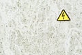 Texture of white iron metal rusty shabby painted paint spit wall yellow warning triangular danger high voltage sign. background Royalty Free Stock Photo