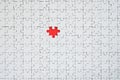 The texture of a white jigsaw puzzle in an assembled state with one missing element forming a red space Royalty Free Stock Photo