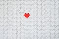 The texture of a white jigsaw puzzle in an assembled state with one missing element forming a red space Royalty Free Stock Photo