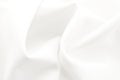 Texture of white satin or silk fabric with waves and rumples. white material