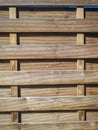 Texture of a wooden plank fence with horizontal and vertical wood strips, brown wooden wall on sunny day Royalty Free Stock Photo