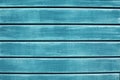 Texture of wooden planks with peeling turquoise blue color paint. Wooden fence texture. Old outdoor red wooden wall background pho Royalty Free Stock Photo