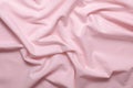 Texture of wrinkled, crumpled natural pink cotton fabric close-up. background for your mockup