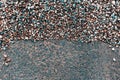Textured abstract background of wet asphalting road and small colorful cold pebbles. Royalty Free Stock Photo
