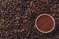 Textured background of coffee beans with bowl of powder