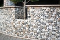 Textured background of Gabion, rock wall with wire meshed fence.