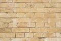 Textured background of a stone brick of yellow antediluvian masonry. Partially destroyed wall. Brick grunge background