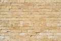 Textured background of a stone brick of yellow antediluvian masonry. Partially destroyed wall. Brick grunge background