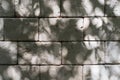 Textured background of stone wall with shadow from tree outdoors, rough decorative light gray large brick. Royalty Free Stock Photo