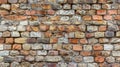 Textured background of weathered brick wall with pattern of multicolored bricks in shades of red, orange, and brown Royalty Free Stock Photo