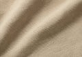 Textured beige fabric with visible weave pattern. The surface displays a series of gentle folds, Royalty Free Stock Photo