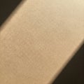 A textured beige surface with intersecting shadows creates a minimalist pattern. The Royalty Free Stock Photo