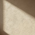 A textured, beige wall is partially illuminated by sunlight casting a Royalty Free Stock Photo