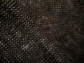 Close-up of a textured black fabric surface featuring a grid pattern with small, circular indents. Royalty Free Stock Photo