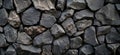 Textured black stone wall with various sizes of rough rocks for construction and design Royalty Free Stock Photo