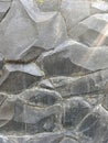 Textured Black Volcanic Rock Wall with Glimmer of Sunlight Royalty Free Stock Photo