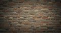 A textured brick wall with a mixture of reddish-brown, gray, and tan bricks. The bricks Royalty Free Stock Photo