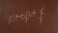 Textured brown chalkboard background. 'Profit' and the dollar sigh are written on the board with a piece of