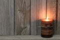 Textured candle lit against wood background