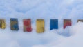 Textured Colorful Painted Blue, Red, Yellow Wooden Picket Fence Planks In Deep Snow, Colorful Rustic Style Background For Vintage Royalty Free Stock Photo