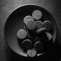 textured cookies in a black plate on a dark background, art food concept, square photo