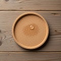 Textured cork coaster rests on a wooden table with visible grain Royalty Free Stock Photo
