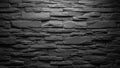 Textured dark grey stacked stone wall with dramatic lighting casting shadows and highlighting rough surfaces Royalty Free Stock Photo