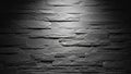 Textured dark grey stacked stone wall with dramatic lighting casting shadows and highlighting rough surfaces Royalty Free Stock Photo