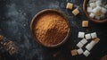 Brown and white sugar in bowls on dark background with scattered cubes Royalty Free Stock Photo