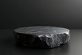 Textured dark stone pedestal against a black background Royalty Free Stock Photo