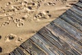 Textured detailed wooden flooring from planks on the sand on the beach with footprints of shoes. Fragment. Texture. In the Algarve Royalty Free Stock Photo