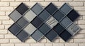 Textured diamond pattern mosaic wall art displayed on a brick surface Royalty Free Stock Photo