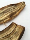 Textured embossed peel of a banana lying on a white background.