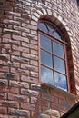 Textured Face Brick Wall of Tower With Arched Window Frame Royalty Free Stock Photo