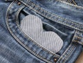 Textured heart fabric background peeks out from pocket blue pants jeans