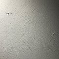Textured light gray wall surface with subtle shadows and imperfections Royalty Free Stock Photo