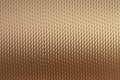 Textured metallic surface with a diamond pattern in a warm bronze hue Royalty Free Stock Photo