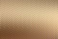 Textured metallic surface with a diamond pattern in a warm golden bronze hue Royalty Free Stock Photo